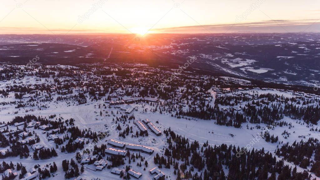 Ski resort at sunset from an aerial view. Norwegian ski region in the mountains in the winter scenery.