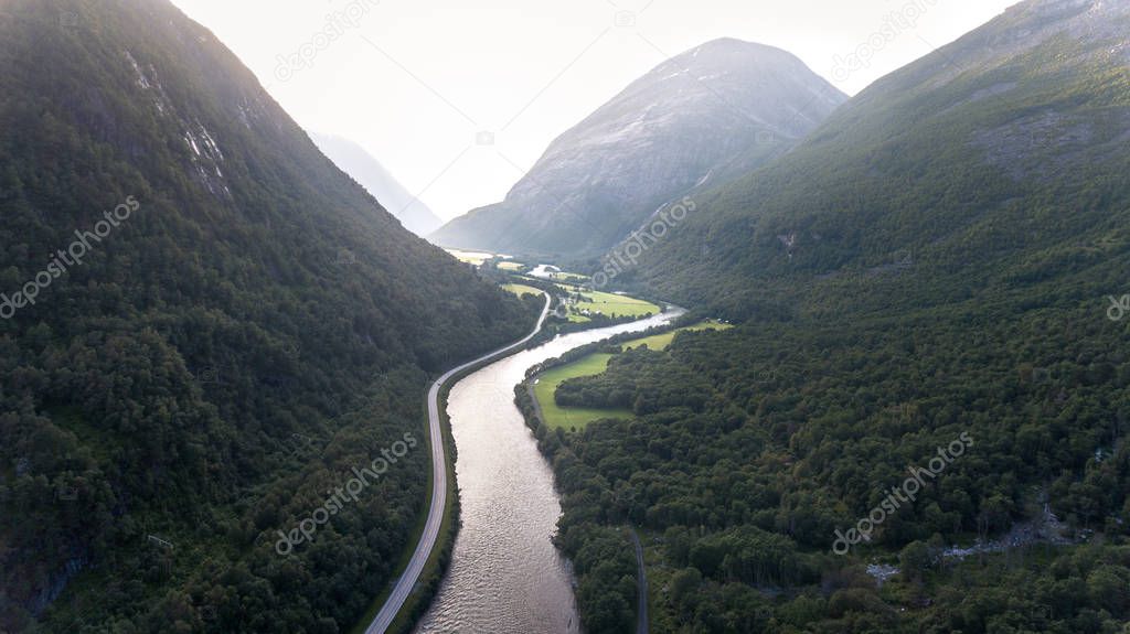 Aerial shot between high mountains in a small mountain valley in Norway.