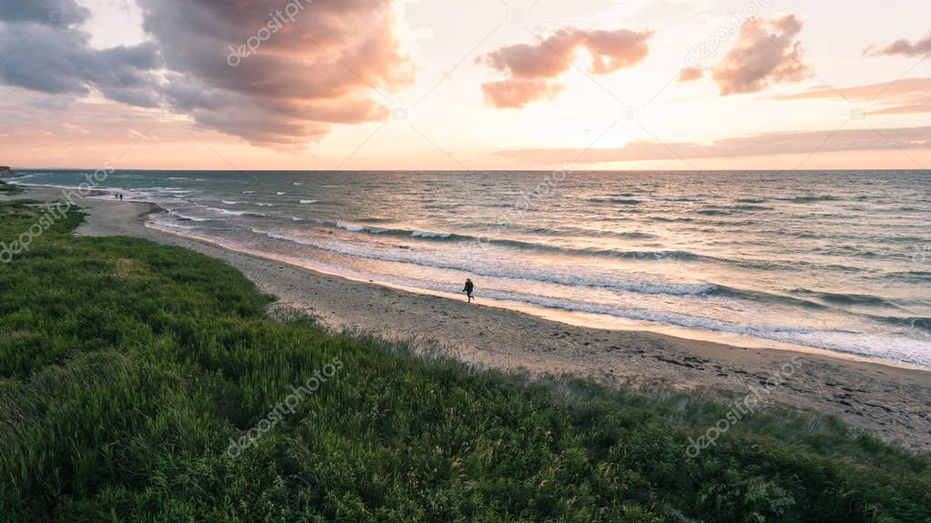 view of Girl running on the beach at sunset