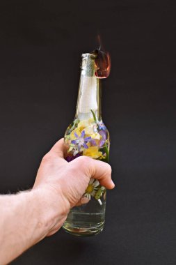 Renkli çiçeklerle dolu molotof kokteyli. Çiçeklerle dolu yanan bir yüzeye yansıtılan sevgi dolu direniş. Soyut eko-savaş.