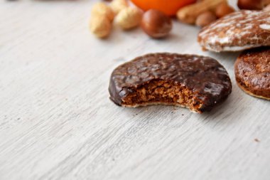 Parlak ahşap bir yüzeyde fındık, fıstık ve ceviz gibi çeşitli fındık türleri vardır. Birkaç lezzetli Alman Elisenlebkuchen 'in yanında.