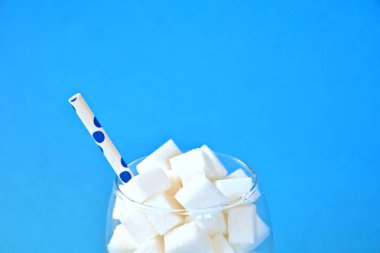 Şeker küpleriyle dolu bir kavanoz sağlıksız bir diyetin ve şeker dolu sağlıksız gıdaların sembolü. Nüfusa aşırı şeker vermek için konsept.