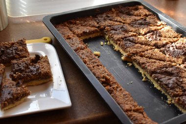 Almanya 'da öğleden sonra kahvesi ve pastası için siyah tepside duran çikolatalı ev yapımı fındık köşeleri aile kutlamaları için nefis ev yapımı pastalar.