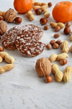Parlak ahşap bir yüzeyde fındık, fıstık ve ceviz gibi çeşitli fındık türleri vardır. Birkaç lezzetli Alman Elisenlebkuchen 'in yanında.