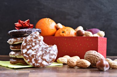 Parlak ahşap bir yüzeyde, birkaç lezzetli Alman Elisenlebkuchen 'in yanında çeşitli fındık türleri vardır. Arka plan olarak Alman zencefilli ekmeği.