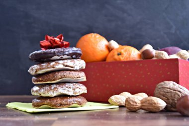 Parlak ahşap bir yüzeyde, birkaç lezzetli Alman Elisenlebkuchen 'in yanında çeşitli fındık türleri vardır. Arka plan olarak Alman zencefilli ekmeği.