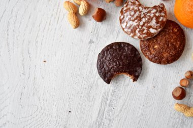 Parlak ahşap bir yüzeyde fındık, fıstık ve ceviz gibi çeşitli fındık türleri vardır. Birkaç lezzetli Alman Elisenlebkuchen 'in yanında.
