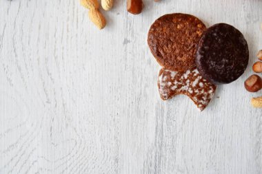Parlak ahşap bir yüzeyde fındık, fıstık ve ceviz gibi çeşitli fındık türleri vardır. Birkaç lezzetli Alman Elisenlebkuchen 'in yanında.