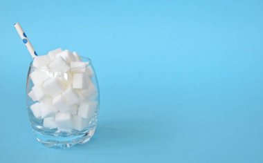 Şeker küpleriyle dolu bir kavanoz sağlıksız bir diyetin ve şeker dolu sağlıksız gıdaların sembolü. Nüfusa aşırı şeker vermek için konsept.