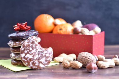 Parlak ahşap bir yüzeyde, birkaç lezzetli Alman Elisenlebkuchen 'in yanında çeşitli fındık türleri vardır. Arka plan olarak Alman zencefilli ekmeği.