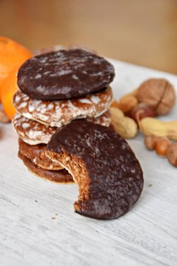 Parlak ahşap bir yüzeyde fındık, fıstık ve ceviz gibi çeşitli fındık türleri vardır. Birkaç lezzetli Alman Elisenlebkuchen 'in yanında.