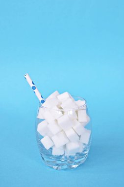 Şeker küpleriyle dolu bir kavanoz sağlıksız bir diyetin ve şeker dolu sağlıksız gıdaların sembolü. Nüfusa aşırı şeker vermek için konsept.