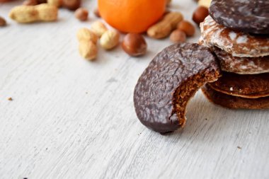 Parlak ahşap bir yüzeyde fındık, fıstık ve ceviz gibi çeşitli fındık türleri vardır. Birkaç lezzetli Alman Elisenlebkuchen 'in yanında.