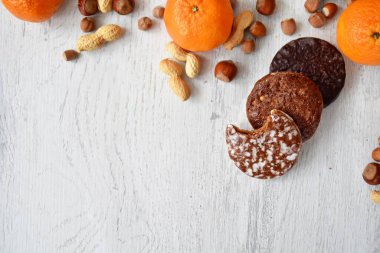 Parlak ahşap bir yüzeyde fındık, fıstık ve ceviz gibi çeşitli fındık türleri vardır. Birkaç lezzetli Alman Elisenlebkuchen 'in yanında.