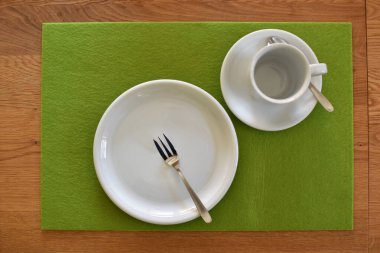 Kahve ve kek için hazırlanmış bir masa üzerinde çatallı bir kek tabağı, bir fincan ve fincan tabağı düz bir arkaplanda - kahve içmek için arka plan ve sıcak bir aile öğleden sonra