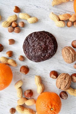 Parlak ahşap bir yüzeyde fındık, fıstık ve ceviz gibi çeşitli fındık türleri vardır. Birkaç lezzetli Alman Elisenlebkuchen 'in yanında.