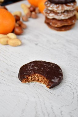 Parlak ahşap bir yüzeyde fındık, fıstık ve ceviz gibi çeşitli fındık türleri vardır. Birkaç lezzetli Alman Elisenlebkuchen 'in yanında.