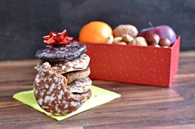 Parlak ahşap bir yüzeyde, birkaç lezzetli Alman Elisenlebkuchen 'in yanında çeşitli fındık türleri vardır. Arka plan olarak Alman zencefilli ekmeği.