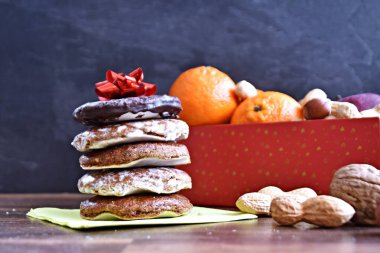 Parlak ahşap bir yüzeyde, birkaç lezzetli Alman Elisenlebkuchen 'in yanında çeşitli fındık türleri vardır. Arka plan olarak Alman zencefilli ekmeği.