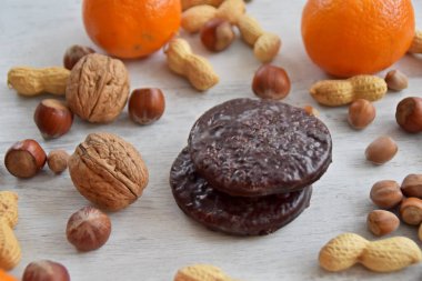 Parlak ahşap bir yüzeyde fındık, fıstık ve ceviz gibi çeşitli fındık türleri vardır. Birkaç lezzetli Alman Elisenlebkuchen 'in yanında.