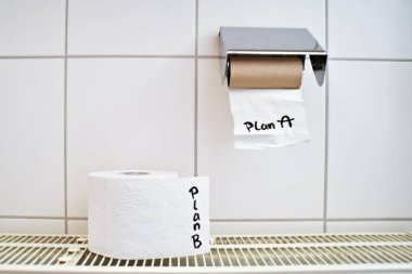 A planının yazıldığı boş bir tuvalet kağıdı rulosu ve diğer planları sembolize eden diğer tuvalet kağıdı rulolarının başarısızlığından kurtulmanın bir yolunu bulmak.