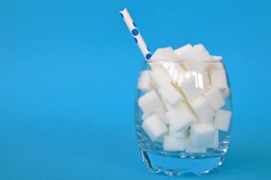 Şeker küpleriyle dolu bir kavanoz sağlıksız bir diyetin ve şeker dolu sağlıksız gıdaların sembolü. Nüfusa aşırı şeker vermek için konsept.