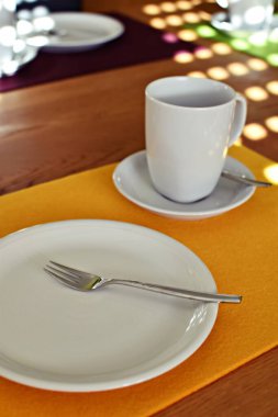 Kahve ve kek için hazırlanmış bir masa üzerinde çatallı bir kek tabağı, bir fincan ve fincan tabağı düz bir arkaplanda - kahve içmek için arka plan ve sıcak bir aile öğleden sonra