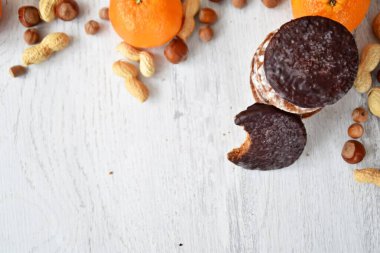 Parlak ahşap bir yüzeyde fındık, fıstık ve ceviz gibi çeşitli fındık türleri vardır. Birkaç lezzetli Alman Elisenlebkuchen 'in yanında.