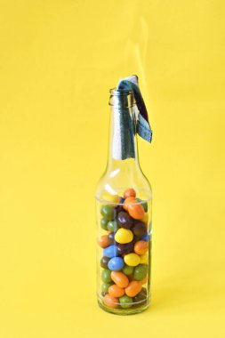 Çocuksu ve gençlik isyanı sembolü olarak renkli çikolata taneleriyle dolu molotof kokteyli. Öğrenci direnci, renkli.
