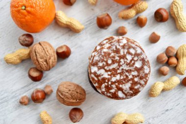 Parlak ahşap bir yüzeyde fındık, fıstık ve ceviz gibi çeşitli fındık türleri vardır. Birkaç lezzetli Alman Elisenlebkuchen 'in yanında.