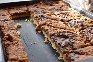Almanya 'da öğleden sonra kahvesi ve pastası için siyah tepside duran çikolatalı ev yapımı fındık köşeleri aile kutlamaları için nefis ev yapımı pastalar.