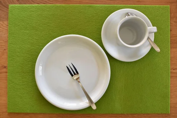 Kahve ve kek için hazırlanmış bir masa üzerinde çatallı bir kek tabağı, bir fincan ve fincan tabağı düz bir arkaplanda - kahve içmek için arka plan ve sıcak bir aile öğleden sonra