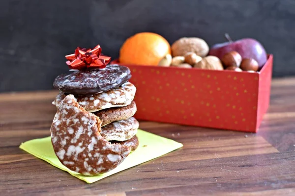 Parlak ahşap bir yüzeyde, birkaç lezzetli Alman Elisenlebkuchen 'in yanında çeşitli fındık türleri vardır. Arka plan olarak Alman zencefilli ekmeği.
