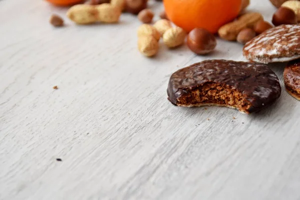 Parlak ahşap bir yüzeyde fındık, fıstık ve ceviz gibi çeşitli fındık türleri vardır. Birkaç lezzetli Alman Elisenlebkuchen 'in yanında.