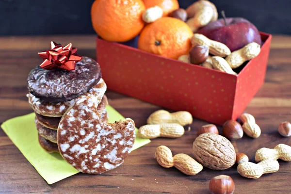 Parlak ahşap bir yüzeyde, birkaç lezzetli Alman Elisenlebkuchen 'in yanında çeşitli fındık türleri vardır. Arka plan olarak Alman zencefilli ekmeği.