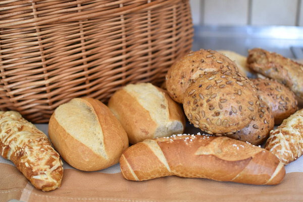Different pastries such as rolls, pretzels, beer sticks and pretzel sticks are placed in front of a bastkorb - concept with fresh rolls from Germany