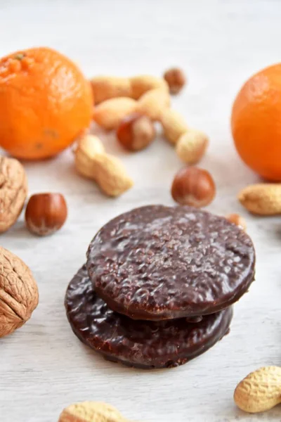 Parlak ahşap bir yüzeyde fındık, fıstık ve ceviz gibi çeşitli fındık türleri vardır. Birkaç lezzetli Alman Elisenlebkuchen 'in yanında.
