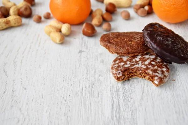 Parlak ahşap bir yüzeyde fındık, fıstık ve ceviz gibi çeşitli fındık türleri vardır. Birkaç lezzetli Alman Elisenlebkuchen 'in yanında.