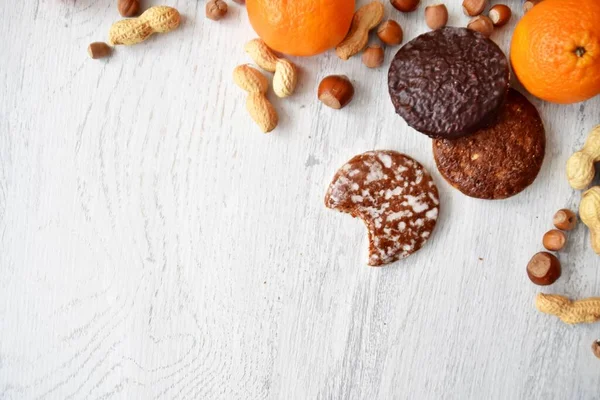 Parlak ahşap bir yüzeyde fındık, fıstık ve ceviz gibi çeşitli fındık türleri vardır. Birkaç lezzetli Alman Elisenlebkuchen 'in yanında.