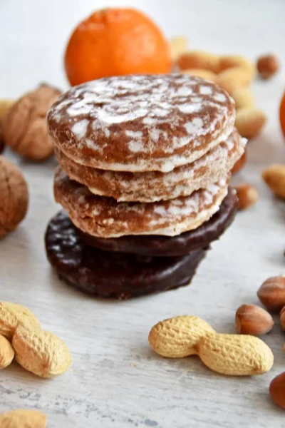 Parlak ahşap bir yüzeyde fındık, fıstık ve ceviz gibi çeşitli fındık türleri vardır. Birkaç lezzetli Alman Elisenlebkuchen 'in yanında.