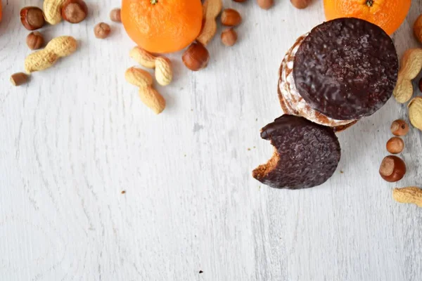 Parlak ahşap bir yüzeyde fındık, fıstık ve ceviz gibi çeşitli fındık türleri vardır. Birkaç lezzetli Alman Elisenlebkuchen 'in yanında.