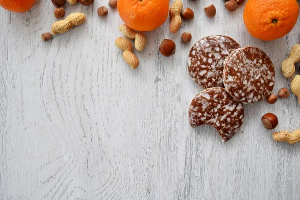 Parlak ahşap bir yüzeyde fındık, fıstık ve ceviz gibi çeşitli fındık türleri vardır. Birkaç lezzetli Alman Elisenlebkuchen 'in yanında.