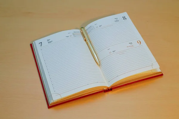 A golden pen is embedded in a notebook — Stock Photo, Image