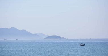Güzel bir deniz manzarası, mesafe görkemli dağlar ortasında yüzen bir yelkenli.