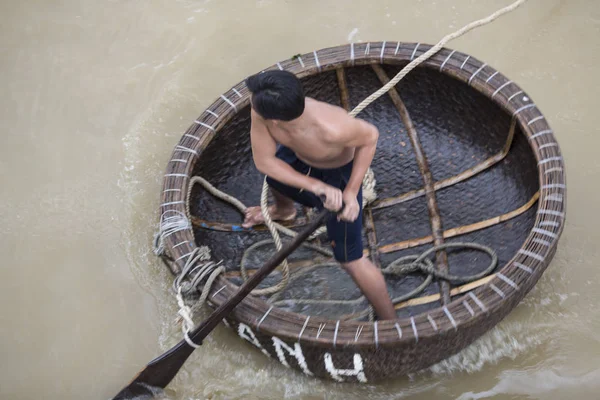 Vietnam: Bir adam ile bir yandan çarklı nehir üzerinde yuvarlak bir tekne içinde
