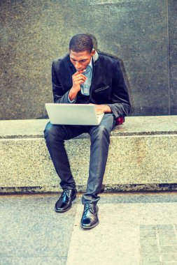 Genç Afro-Amerikan dışında dizüstü bilgisayarda çalışan adam