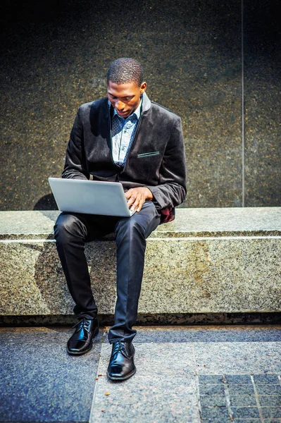 Joven hombre afroamericano que trabaja en el ordenador portátil fuera en — Foto de Stock