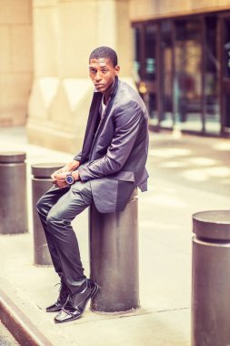 New York'ta sokakta genç Afrikalı-Amerikalı adam siting relaksin