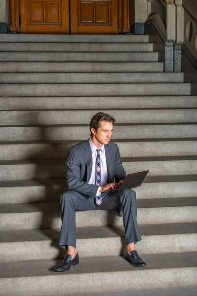 Empresario americano trabajando en el ordenador portátil, sentado en las escaleras — Foto de Stock