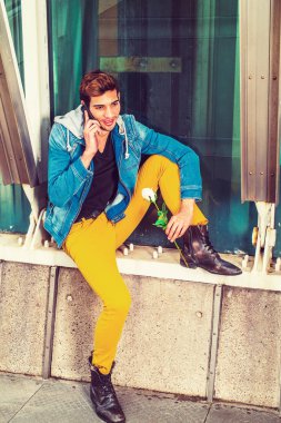 N dışında cep telefonuyla konuşan genç adam beyaz gül, holding